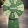 Custom green spin the wheel display with Tezenis branding, featuring discount offers and prize segments, used for retail promotions and in-store customer engagement.