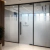 Frosted glass office partition with geometric pattern and Pinnacle Consulting Dubai logo.