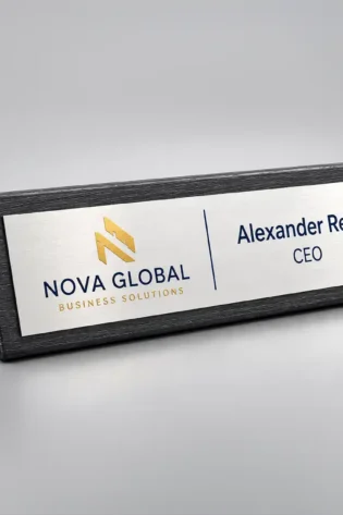 Black wooden finish acrylic desk name plate with a silver plate featuring a UV-printed name, designation and company logo