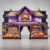 Purple haunted-house Halloween entrance arch with pumpkin graphics and a central doorway