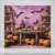 Square Halloween backdrop with orange pumpkins, lanterns and black bats against a purple background
